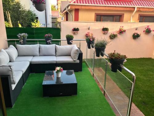 a patio with a couch and a table and plants at Villa Italia Boutique in Mamaia Sat/Năvodari
