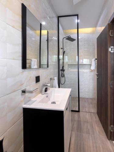 a bathroom with a sink and a shower at Executive Cozy Suite at THE HIDDEN DOMUS I Wenchi Suite in Accra