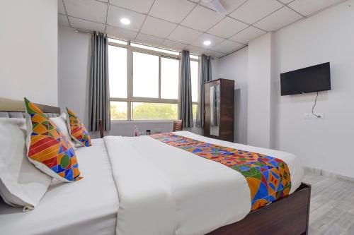 a bedroom with a large white bed and a television at FabHotel Connect in Jaipur