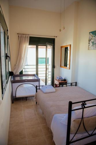 two beds in a room with a view of the ocean at Iris apartment 1 in Anaxos