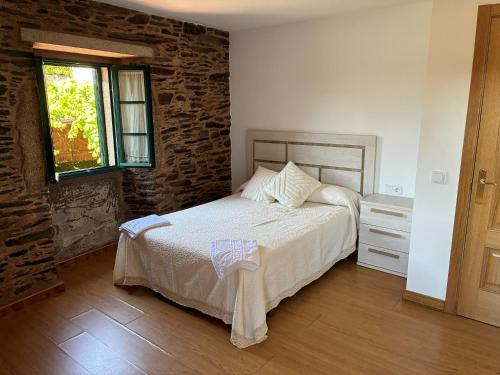 a bedroom with a bed and a brick wall at Casa Brandelos in Bama