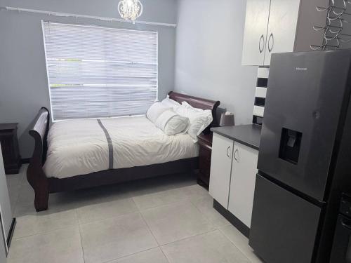 a small kitchen with a small bed and a refrigerator at CCV Beach House in Bay View