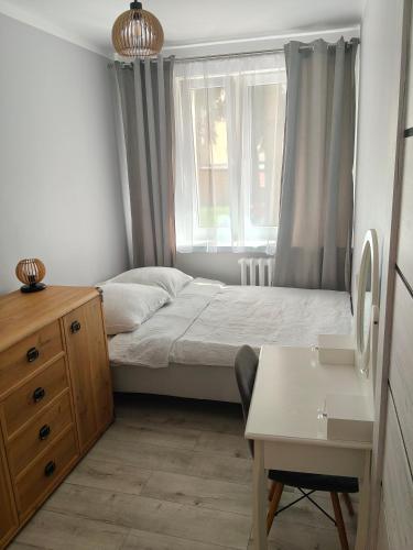 ein kleines Schlafzimmer mit einem Bett und einem Fenster in der Unterkunft APT w centrum in Suwałki