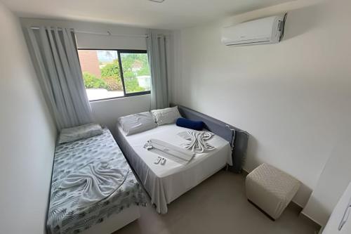 a small bedroom with a bed and a window at Porto bello condomínio in Porto De Galinhas