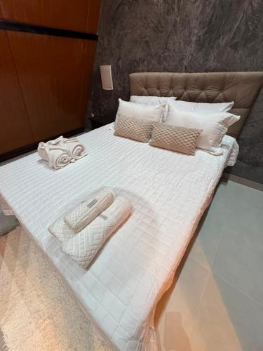 a large white bed with two towels on it at Chalé lago Azul in Venda Nova do Imigrante