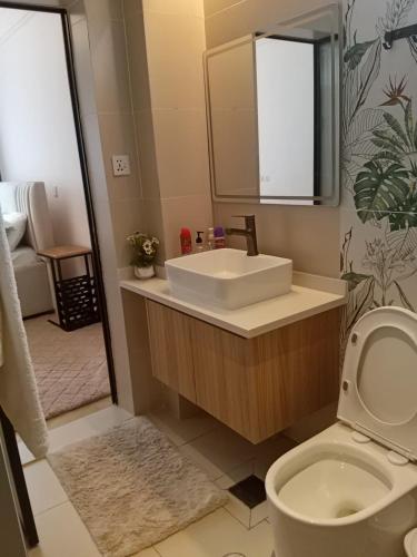a bathroom with a sink and a toilet and a mirror at Artesano A71 in Nairobi