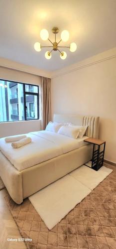 a bedroom with a large bed and a window at Artesano A71 in Nairobi
