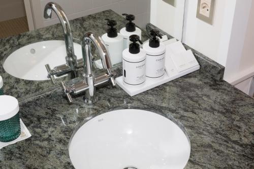 a bathroom counter with a sink and a toilet at Hôtel Maison Borrèze in Souillac