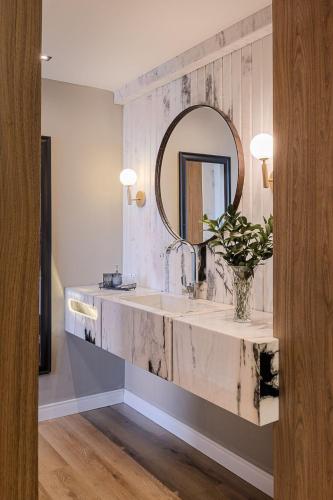 a bathroom with a marble sink and a mirror at Havana Palace Hotel II Uberaba in Uberaba