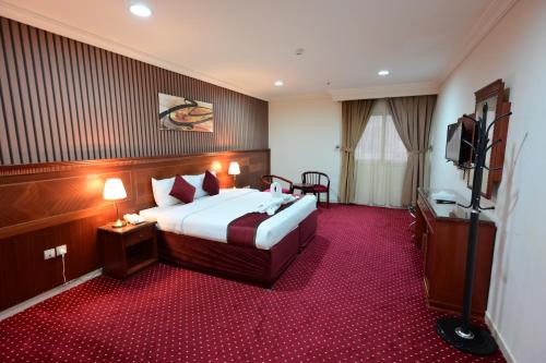 a hotel room with a bed and a television at فندق وفاق صدقي in Al ‘Azīzīyah