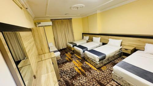 a hotel room with two beds and a couch at اكليل البيت in Al ‘Utaybīyah