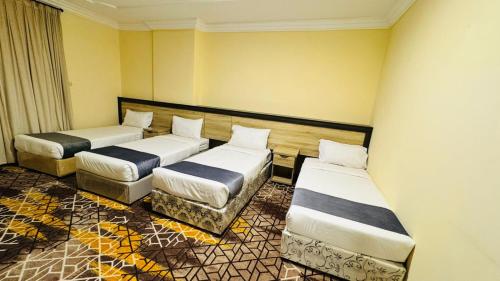 two beds in a room with yellow walls at اكليل البيت in Al ‘Utaybīyah