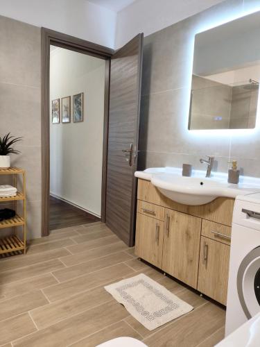 a bathroom with a sink and a washing machine at Etherio in Makrygialos