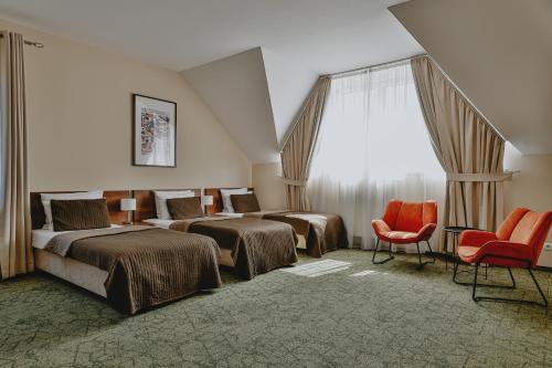 ein Hotelzimmer mit zwei Betten und zwei Stühlen in der Unterkunft Hotel Kantoria in Tarnów