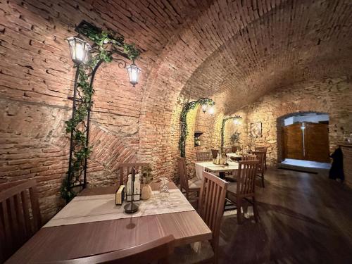 a dining room with a table and a brick wall at Pensiunea Gasthaus Alte Post in Sighişoara