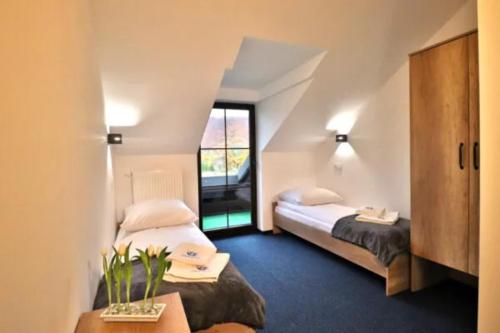 a hotel room with two beds and a window at Noclegi Onesto in Międzybrodzie Bialskie