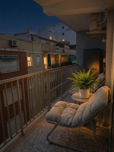 a balcony with a couch and a table with a plant at Cullera Beach III in Cullera