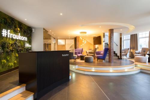 a lobby of a hotel with purple chairs and tables at Hotel Künstlerquartier Seezeichen in Ahrenshoop