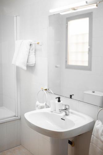 a white bathroom with a sink and a mirror at SUNDOS Feria Valencia in Valencia