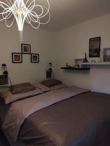 a bedroom with a large bed with a chandelier at Niki Vendégház in Abaliget