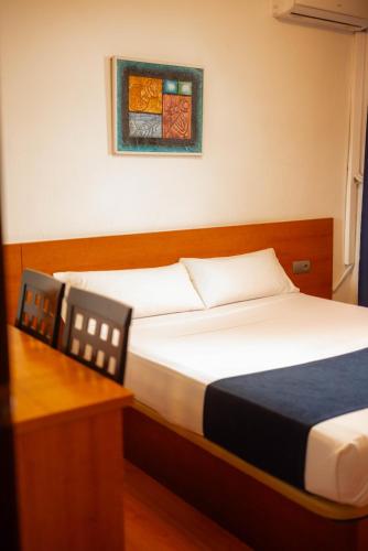 a bedroom with two beds and a desk and a picture at SUNDOS Feria Valencia in Valencia