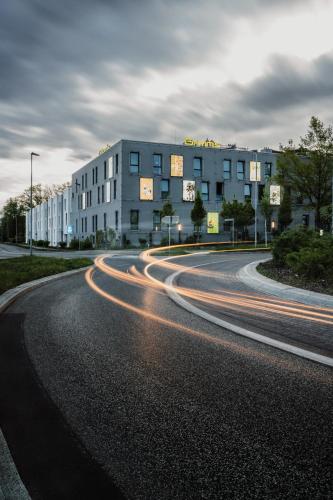 an empty street with a building and cars at Grimm´s Berlin Potsdam in Teltow