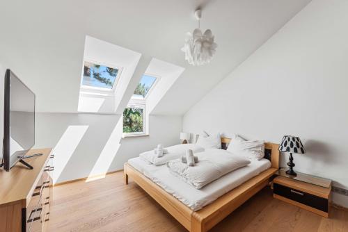 a white bedroom with a bed and a window at Villa Donau - Sauna & Whirlpool in Vienna