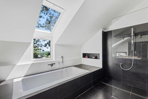 a bathroom with a bath tub and a window at Villa Donau - Sauna & Whirlpool in Vienna