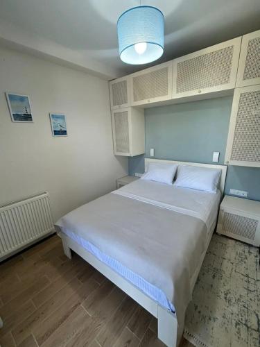 a bedroom with a white bed and a blue light at terrace kaprovan in Urekis Sadguri