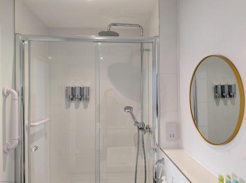 a bathroom with a shower and a mirror at Wyndham Court - Midhurst in Midhurst