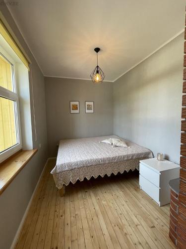 a bedroom with a bed and a window at Tulika korter in Paralepa