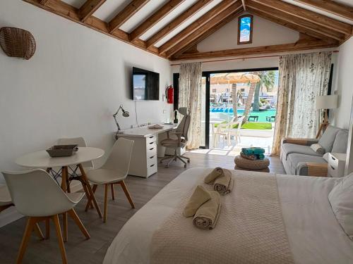 a bedroom with a bed and a table and a desk at Casas Lapa in Costa Teguise