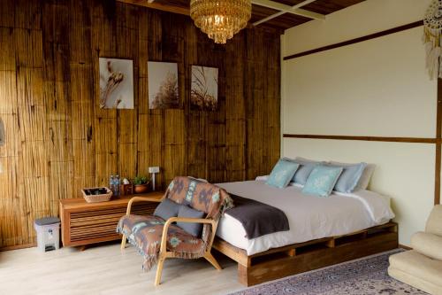 a bedroom with a bed and a chair and a desk at พอยื้อใจ doichang in Ban Huai Khai