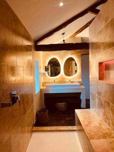 a bathroom with a sink and a mirror at Maison Laroque & Spa in Bellefont-La Rauze
