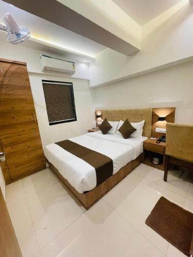 a hotel room with a bed and a desk and a bed at HOTEL BLACK BURN in Mumbai