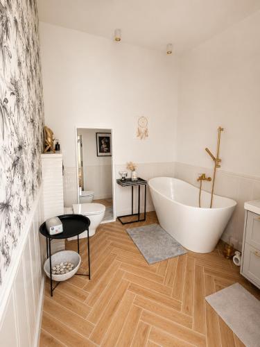 a bathroom with two large tubs and a sink at LOG apartament in Dobrzewino