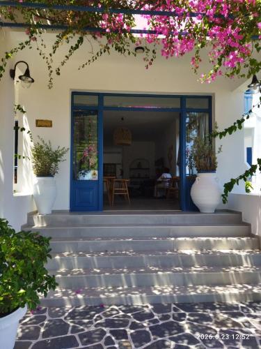 a house with a blue door and some flowers at Hotel Flisvos in Megalochori
