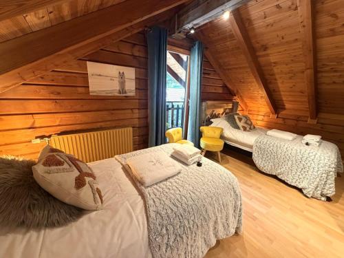 a bedroom with two beds in a log cabin at LE GRIZZLY Chalet en bois avec SPA Jacuzzi in La Bresse