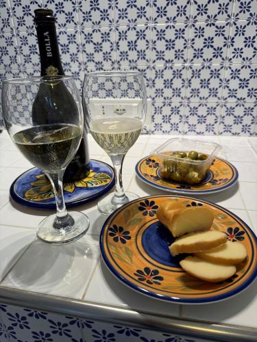 a table with two glasses of wine and a plate of food at Victoria House Scopello in Scopello