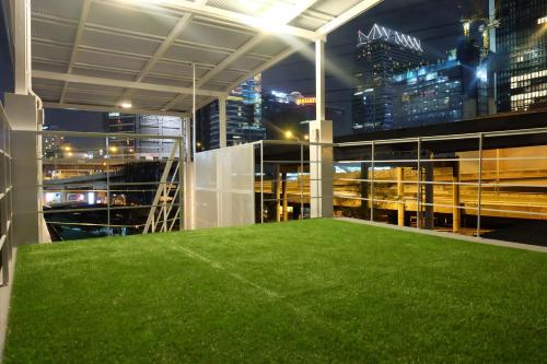 a green lawn in the middle of a building at night at On the Bed Hostel in Bangkok