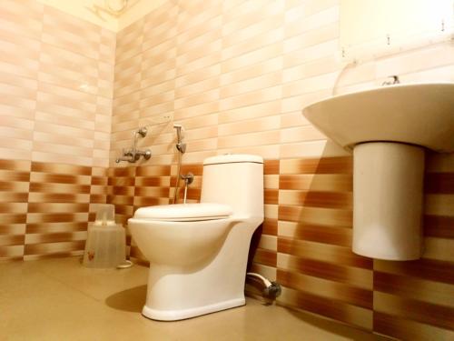 a bathroom with a toilet and a sink at Regal residency in Perintalmanna