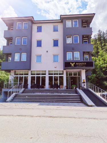 a large building with stairs in front of it at Hotel Aventus -Novi Pazar Banja in Novi Pazar
