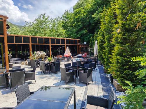 a patio with tables and chairs and a building at Hotel Aventus -Novi Pazar Banja in Novi Pazar