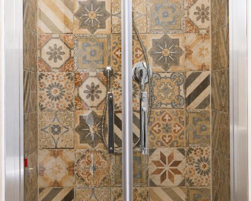 a bathroom with a shower with tiles on the wall at Albergo dell'Angelo in Pieve di Teco