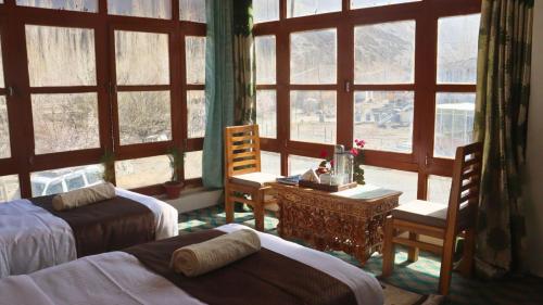a bedroom with two beds and a large window at Wanla Eco Residence in Tarklak