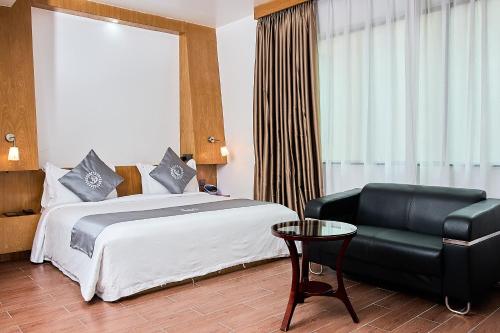 a hotel room with a bed and a chair at La Maison Royale in Nairobi