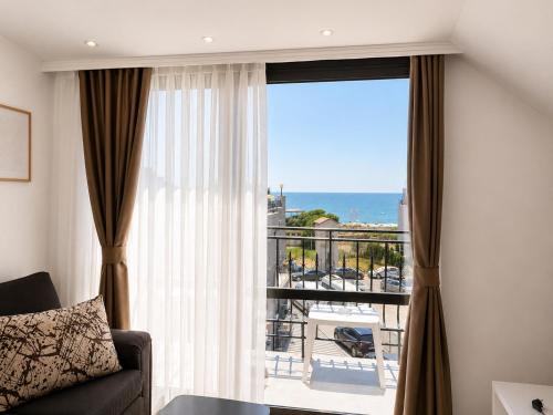 a living room with a window with a view of the ocean at Adeti Residence in Nesebar