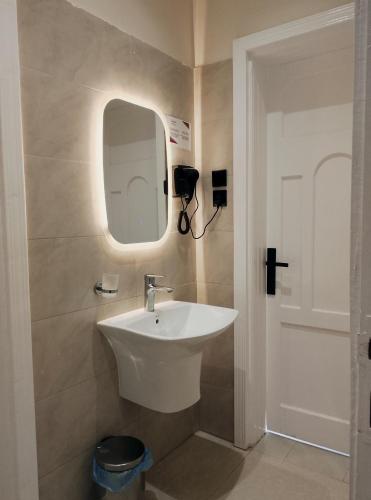 a bathroom with a white sink and a mirror at شاليهات المروان لبيوت العطلات - AL-Marwan for Holiday Homes in Ash Shafa