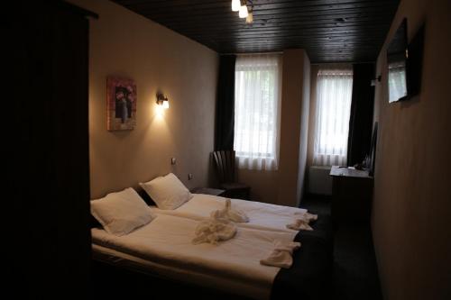 a bedroom with a bed with stuffed animals on it at Family hotel Valchanovata Kashta in Fotinovo