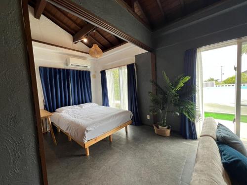 a bedroom with a bed and a large window at MOTOBU Ocean Private Villa in Motobu